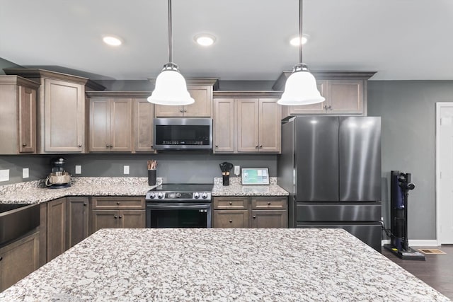 145 Diane Loop, White Bluff, TN 37187 - kitchen with stainless steel appliances, wood finished floors, baseboards, light stone counters, and recessed lighting