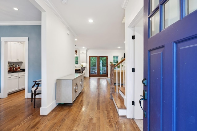 foyer featuring ornamental molding, stairway, light wood-style floors, recessed lighting, and baseboards