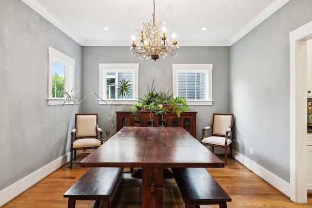 dining space featuring a chandelier, light wood-style flooring, crown molding, baseboards, and recessed lighting