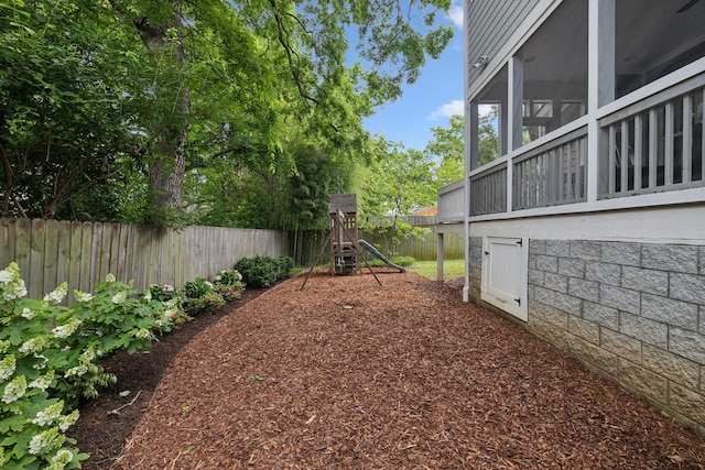 fenced backyard with a playground