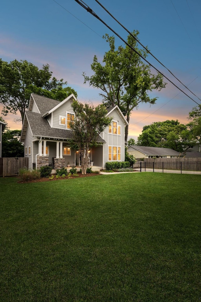 view of front of property with covered porch, stone siding, and roof with shingles