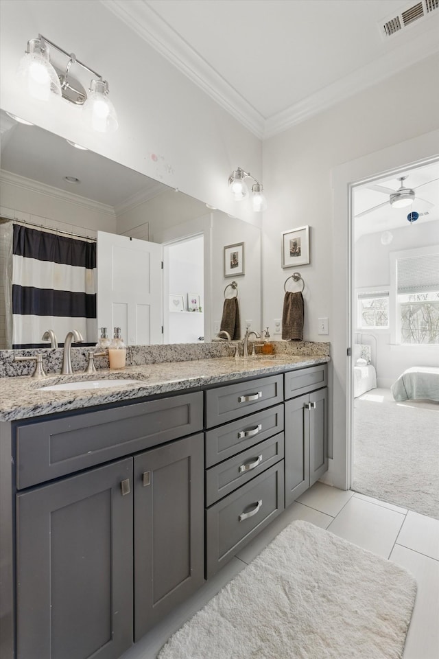 ensuite bathroom with crown molding, tile patterned floors, and double vanity