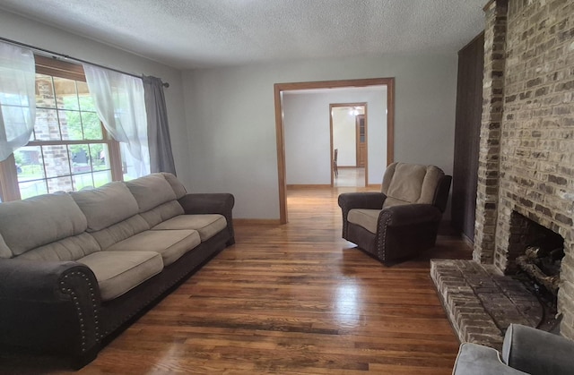 525527 Shady Grove Rd, Sequatchie, TN 37374 - living room featuring wood finished floors, a textured ceiling, a brick fireplace, and baseboards