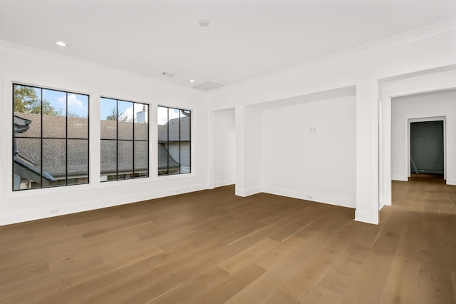 unfurnished room featuring crown molding, wood finished floors, baseboards, and recessed lighting