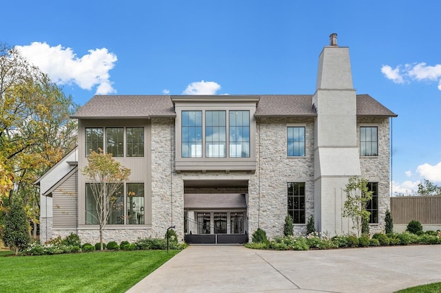 view of front of home featuring stone siding, a chimney, french doors, a front yard, and a shingled roof