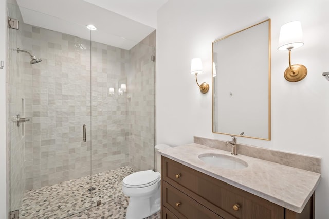 full bathroom with a shower stall, toilet, and vanity