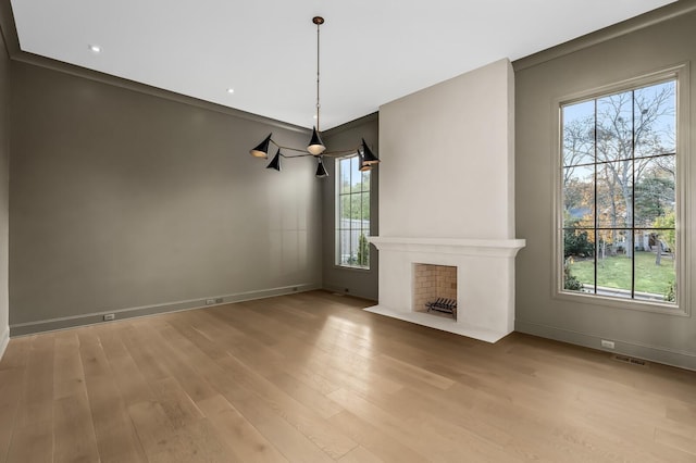 unfurnished living room featuring light wood-style floors, baseboards, and a fireplace with flush hearth