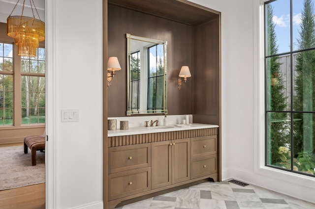 bathroom with vanity, baseboards, and a chandelier