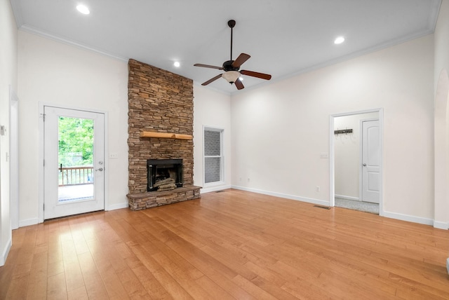 unfurnished living room with ceiling fan, light wood-style floors, crown molding, a fireplace, and baseboards