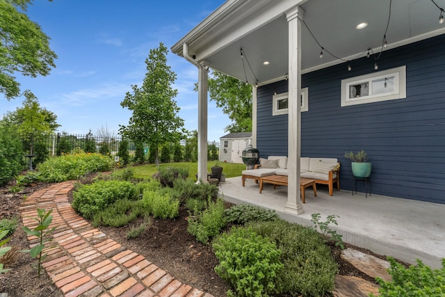 view of yard with a patio area, an outdoor living space, fence, a storage shed, and an outdoor structure