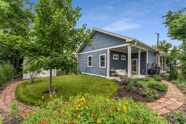 rear view of house featuring a patio and an outbuilding