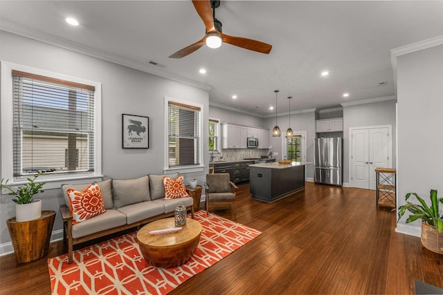 living area with recessed lighting, ceiling fan, dark wood-style flooring, baseboards, and crown molding
