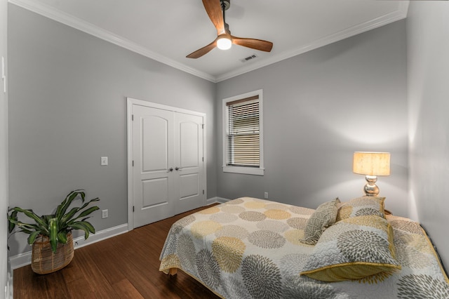 bedroom featuring baseboards, dark wood-style flooring, crown molding, a ceiling fan, and a closet