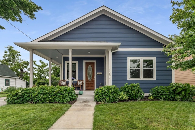 view of front of home featuring covered porch and a front lawn