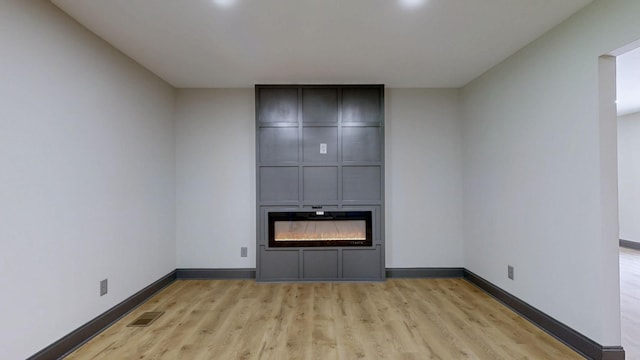 2038 Ogburn Chapel Rd, Clarksville, TN 37042 - unfurnished living room featuring light wood-style flooring, baseboards, and a fireplace
