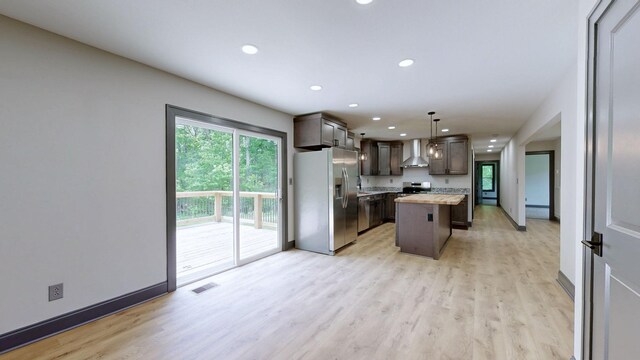 2038 Ogburn Chapel Rd, Clarksville, TN 37042 - kitchen featuring stainless steel appliances, wall chimney exhaust hood, light countertops, light wood-style flooring, and recessed lighting
