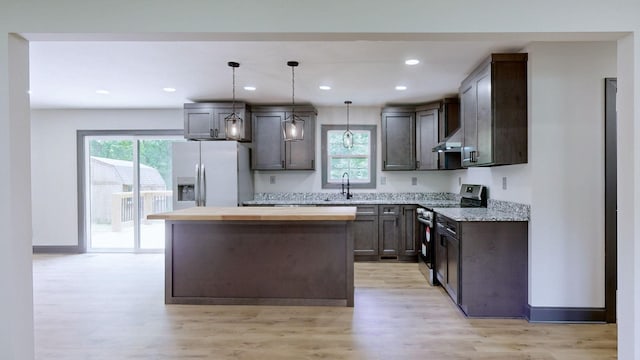 2038 Ogburn Chapel Rd, Clarksville, TN 37042 - kitchen featuring stainless steel range with electric cooktop, fridge with ice dispenser, a sink, under cabinet range hood, and light wood-style flooring