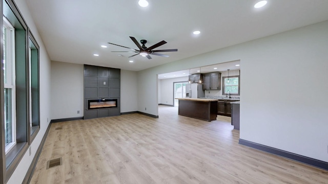 2038 Ogburn Chapel Rd, Clarksville, TN 37042 - unfurnished living room featuring light wood-type flooring, recessed lighting, a sink, and baseboards