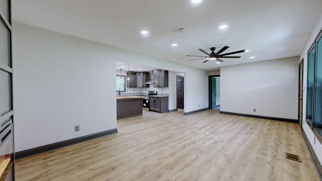2038 Ogburn Chapel Rd, Clarksville, TN 37042 - unfurnished living room with light wood-style flooring, recessed lighting, baseboards, a ceiling fan, and a sink