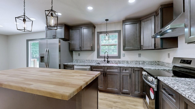 2038 Ogburn Chapel Rd, Clarksville, TN 37042 - kitchen with stainless steel appliances, a sink, butcher block counters, wall chimney exhaust hood, and recessed lighting