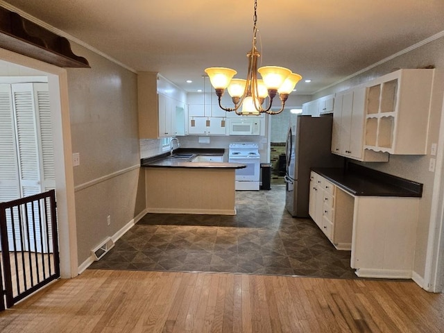 1309 Jackson Dr, Pulaski, TN 38478 - kitchen with white appliances, a chandelier, dark countertops, a sink, and ornamental molding