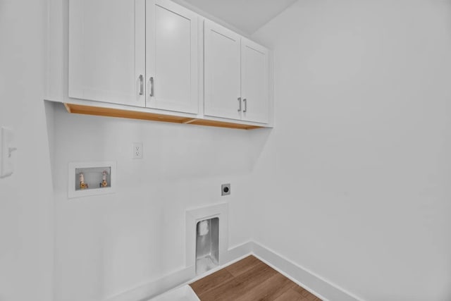 clothes washing area with cabinet space, hookup for an electric dryer, washer hookup, baseboards, and dark wood-type flooring