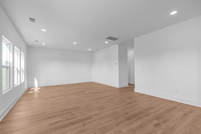 unfurnished room featuring baseboards, light wood finished floors, and recessed lighting