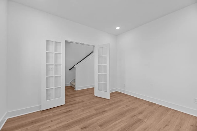 unfurnished room featuring light wood-style floors, baseboards, stairs, and recessed lighting