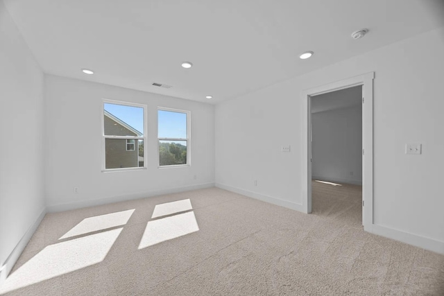 unfurnished room with light colored carpet, baseboards, and recessed lighting