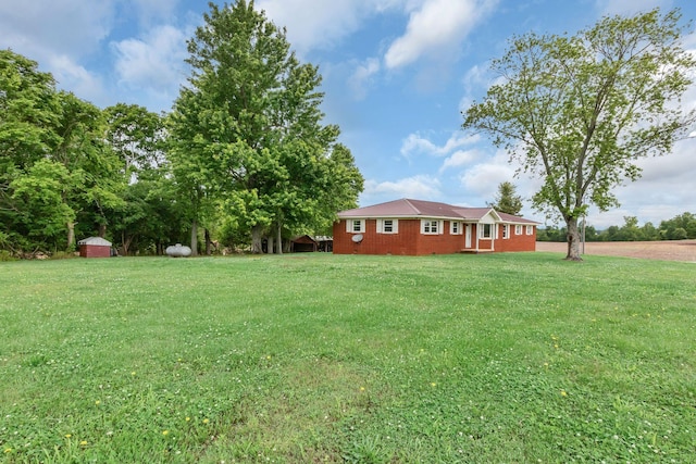 view of grassy yard featuring a storage shed and an outdoor structure