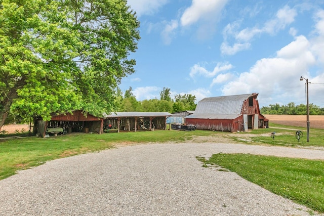 surrounding community with a barn, a yard, driveway, and an outdoor structure