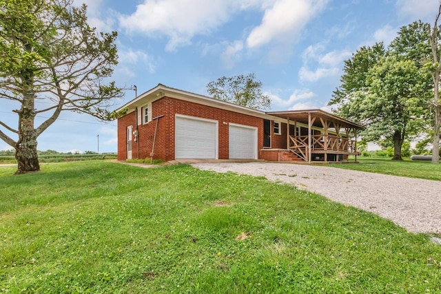 view of front of property featuring brick siding, an attached garage, a front lawn, a porch, and gravel driveway