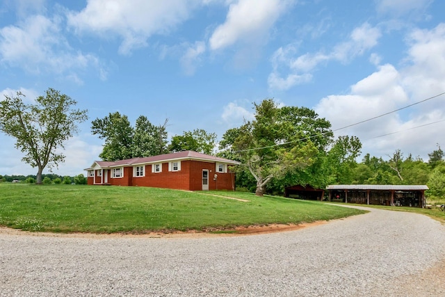view of side of property with driveway and a lawn