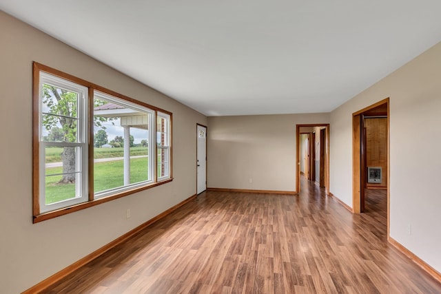 unfurnished room with light wood-style flooring, plenty of natural light, and baseboards