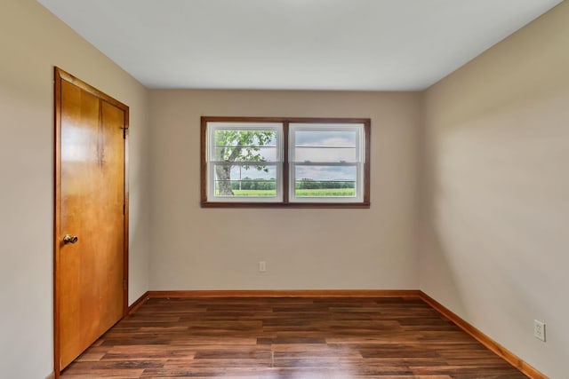 unfurnished bedroom with wood finished floors, baseboards, and a closet
