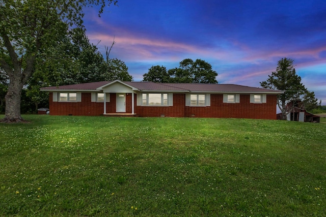 ranch-style home with brick siding, a front lawn, and metal roof
