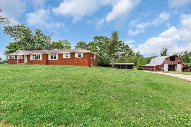 view of green lawn featuring a barn and an outdoor structure