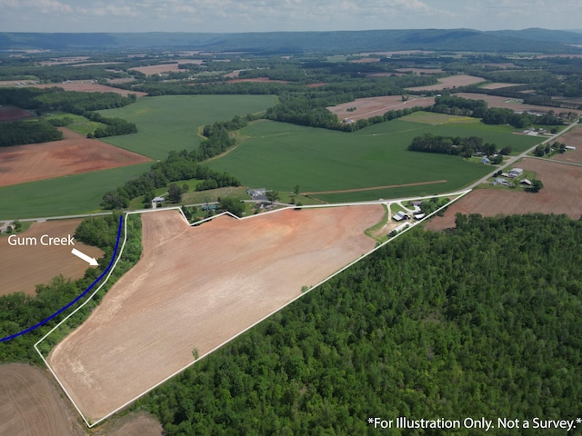 aerial view of property's location featuring property boundaries highlighted, rural landscape, and a heavily wooded area