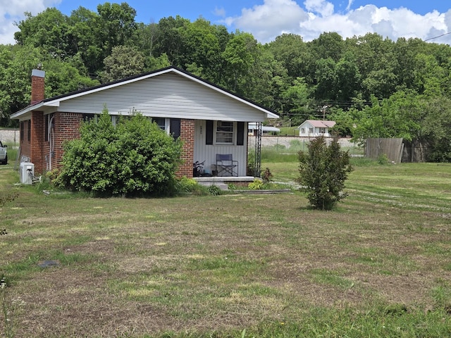 307 E Commerce St, Waverly, TN 37185 - view of front of home featuring a porch, brick siding, and a chimney