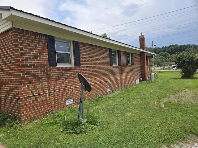 307 E Commerce St, Waverly, TN 37185 - view of side of property featuring a yard, a chimney, brick siding, central air condition unit, and crawl space