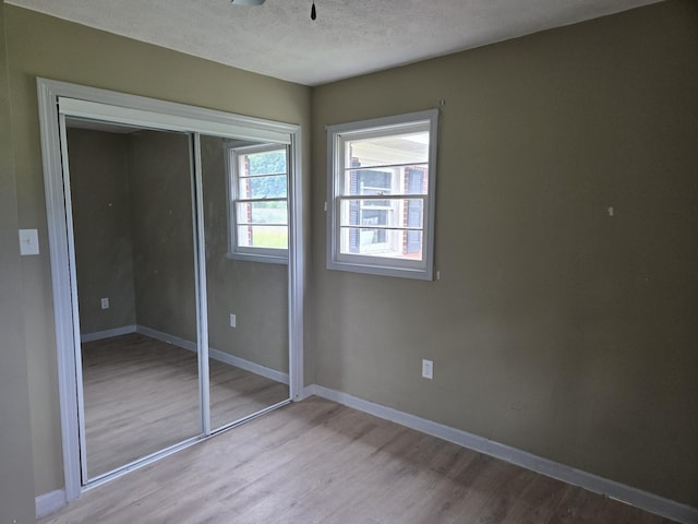 307 E Commerce St, Waverly, TN 37185 - unfurnished bedroom with light wood-type flooring, a closet, baseboards, and a textured ceiling