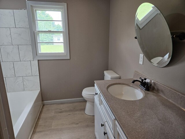 307 E Commerce St, Waverly, TN 37185 - full bathroom featuring toilet, vanity, a tub to relax in, wood finished floors, and baseboards