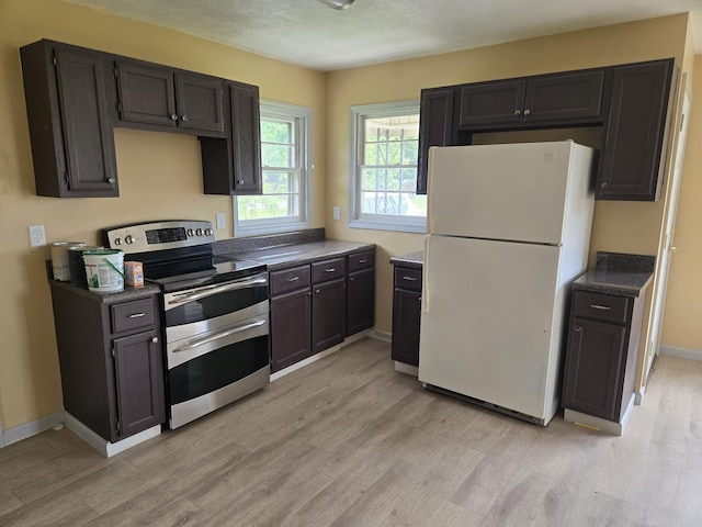 307 E Commerce St, Waverly, TN 37185 - kitchen featuring freestanding refrigerator, double oven range, light wood finished floors, and dark countertops