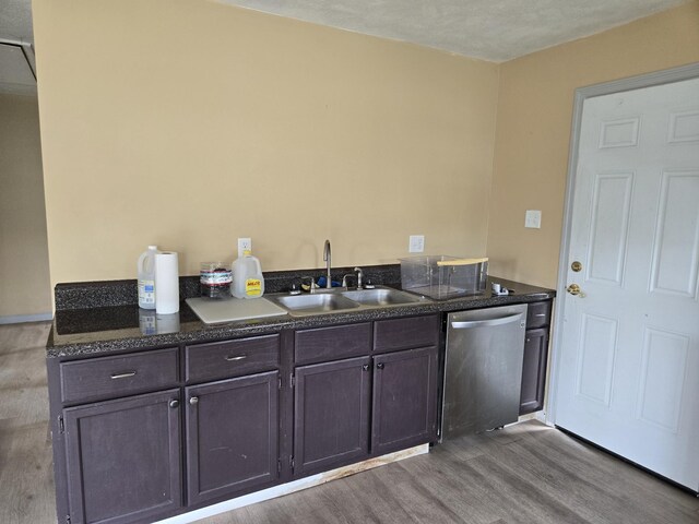 307 E Commerce St, Waverly, TN 37185 - kitchen featuring stainless steel dishwasher, a sink, wood finished floors, dark brown cabinetry, and dark stone countertops