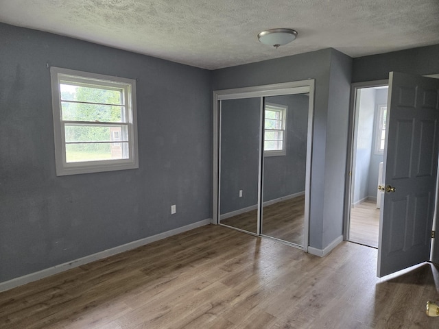 307 E Commerce St, Waverly, TN 37185 - unfurnished bedroom with wood finished floors, a textured ceiling, baseboards, and a closet