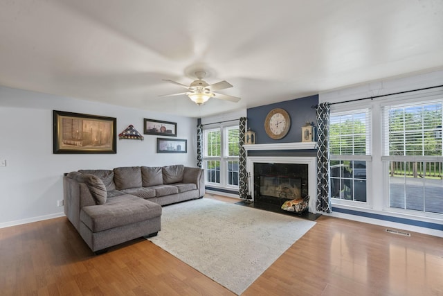3630 W Trimble Rd, Milton, TN 37118 - living area featuring wood finished floors, baseboards, a ceiling fan, and a fireplace with flush hearth