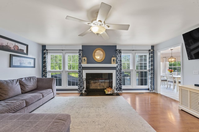 3630 W Trimble Rd, Milton, TN 37118 - living room with wood finished floors, a ceiling fan, and a fireplace with flush hearth