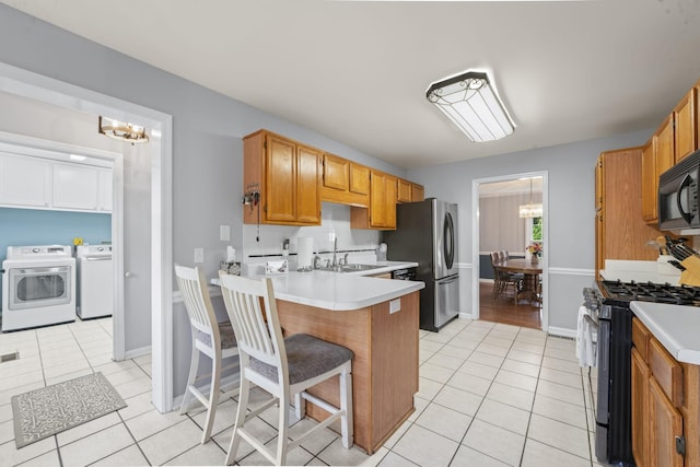 3630 W Trimble Rd, Milton, TN 37118 - kitchen with range with gas cooktop, a chandelier, washing machine and dryer, freestanding refrigerator, and a sink