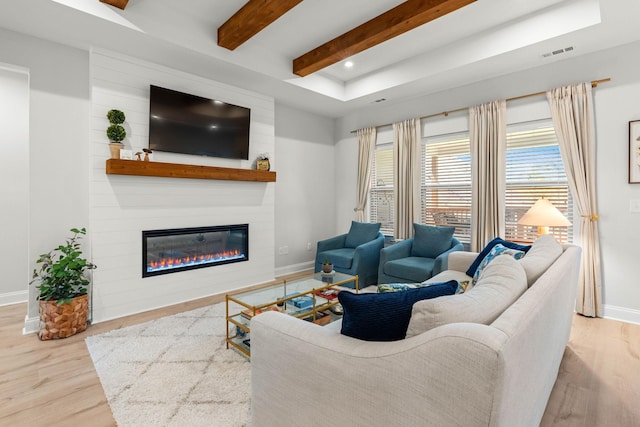 living room featuring beam ceiling, wood finished floors, baseboards, a large fireplace, and recessed lighting