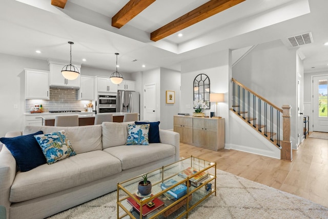 living room featuring recessed lighting, light wood-type flooring, stairway, and beamed ceiling